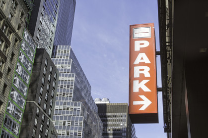 A parking sign in front of a city scape