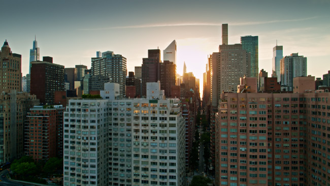 Drone shot of New York City on a summer evening, taken from over the East River and looking towards Midtown Manhattan.