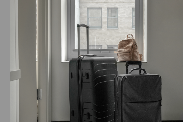 Suitcases in front of a window looking out on NYC buildings