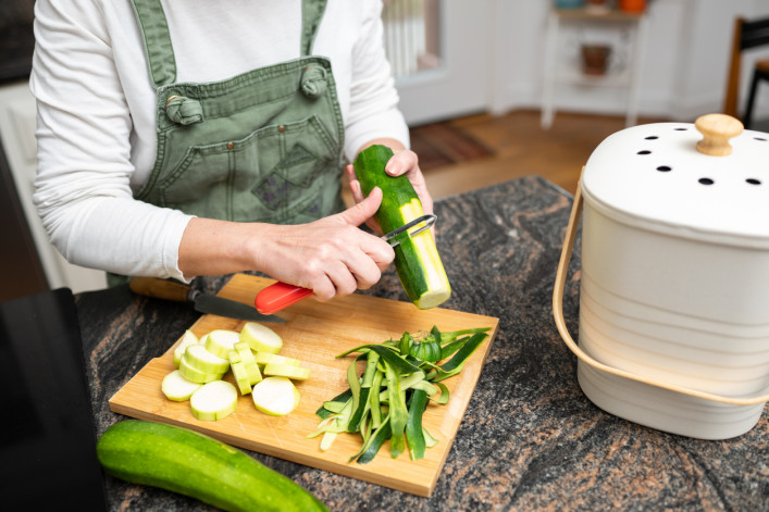 Women cooking uses compost bin