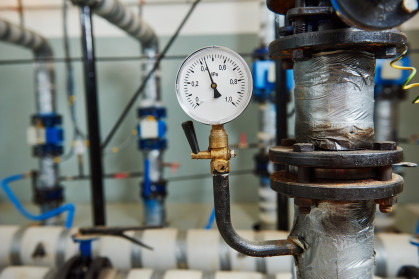 Closeup of manometer, pipes and faucet valves of heating system in a boiler room