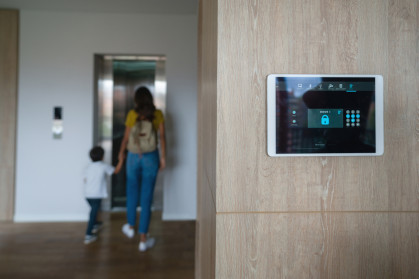 Mother and son leaving the house and locking the door using an automated security system