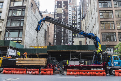 Construction works on Fifth Avenue (5th Avenue) with heavy industrial machines and workers in Manhattan in New York City, USA