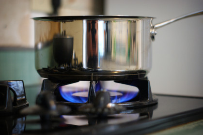 stainless steel saucepan being used on a gas cooktop