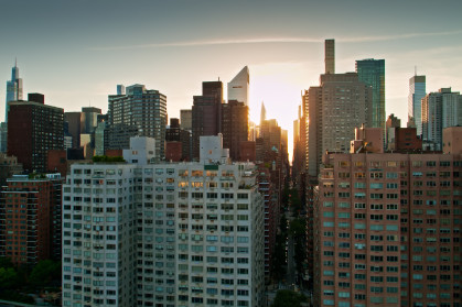 Drone shot of New York City on a summer evening, taken from over the East River and looking towards Midtown Manhattan.