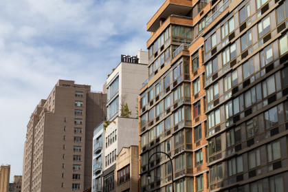 A row of a variety of apartment buildings and skyscrapers along a street in Greenwich Village of New York City