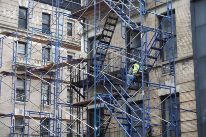 New York, USA - June 21, 2019: Image of a construction worker resting on a scaffold.