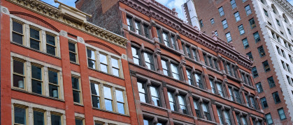 Row of three red brick apartment buildings in NYC