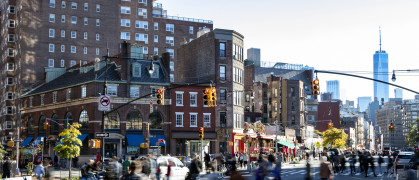 Busy crowds of people walking across the street at 7th Avenue in the Greenwich Village neighborhood of New York City NYC