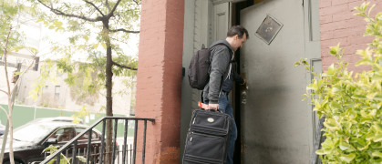 Traveling Man Arriving with Suitcase to NYC Residence Enters Doorway