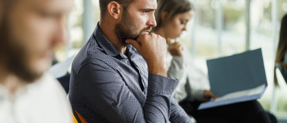 Worried white man, thinking, in board room.