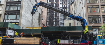 Construction works on Fifth Avenue (5th Avenue) with heavy industrial machines and workers in Manhattan in New York City, USA