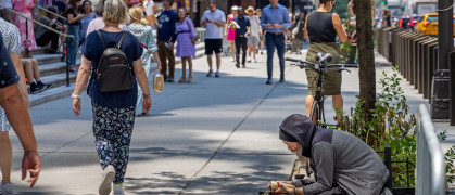 Pedestrians and homeless man on 5th Avenue in Manhattan