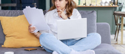 Young freelancer woman get over paperwork while working from living room stock photo