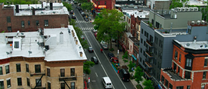 New York City on a hazy day in summer, following traffic on Nostrand Avenue in Crown Heights, Brooklyn.