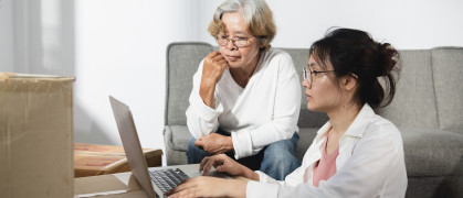 The concept of moving rooms and new houses, Asian teenage and elderly women, mother and daughter are chatting During the use of the laptop. stock photo