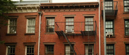 Classic pre-war style brick apartment buildings stand closely together, showing the density of new york city