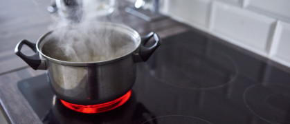 Shot of water boiling in an open pot on a hot stove at home