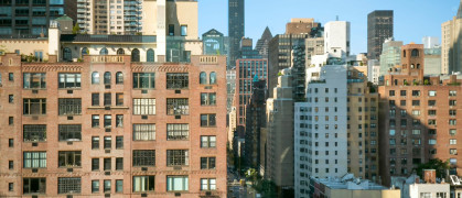 Urban cityscape of New York City showcasing diverse architecture under a clear blue sky.