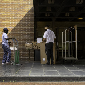 Postman transferring packages to the doorman of a residential building on Madison Avenue