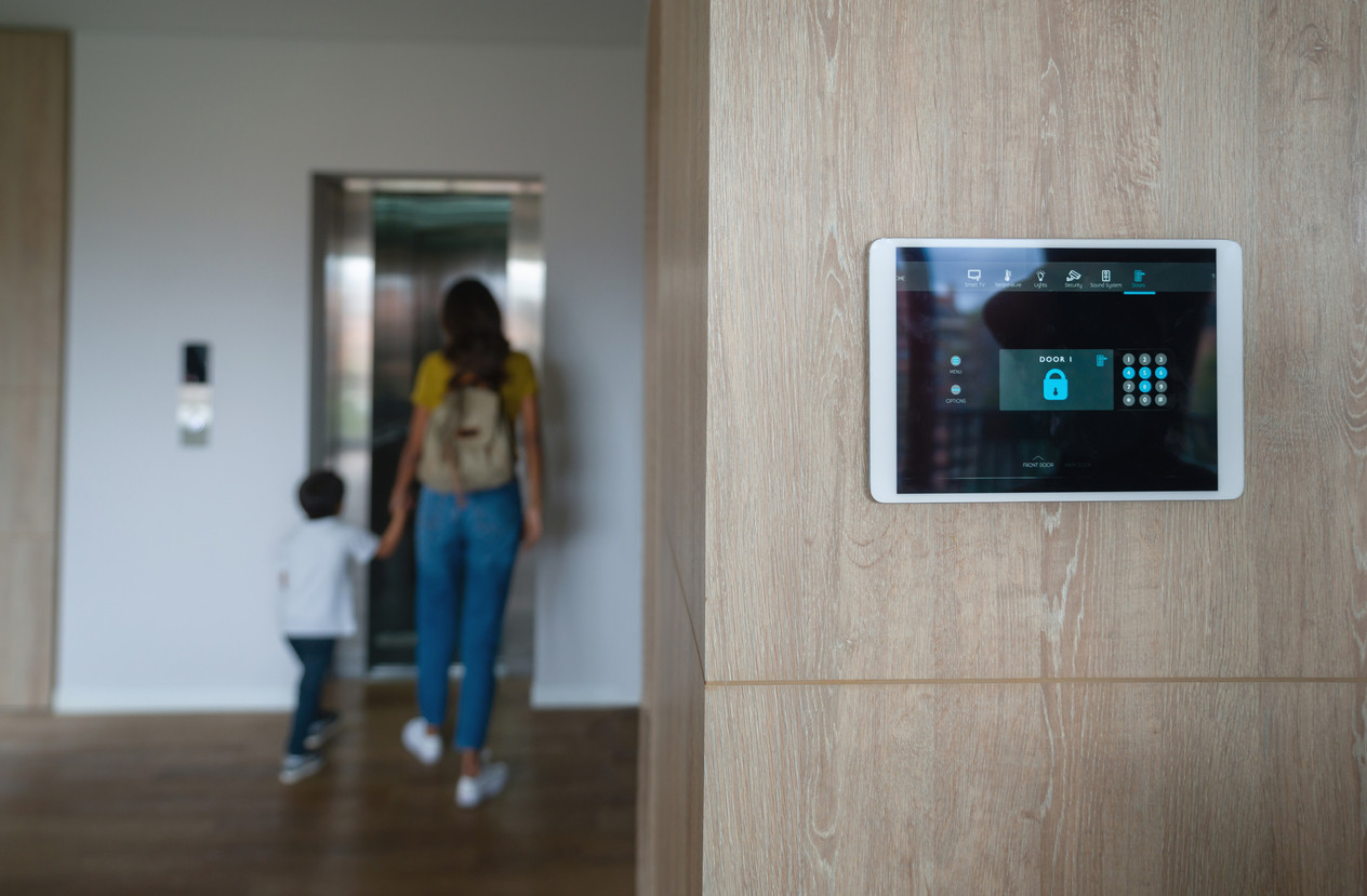 Mother and son leaving the house and locking the door using an automated security system